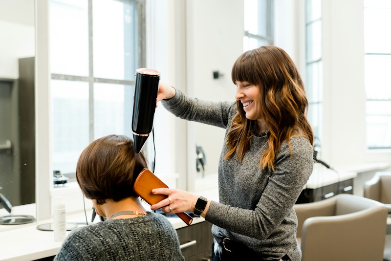 A stylist working on a guest’s hair in a salon